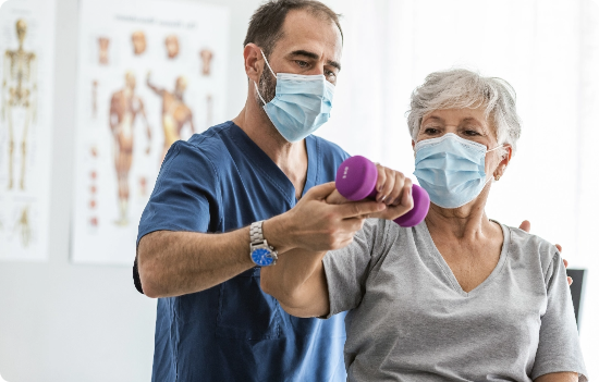 A nurse helping an older patient with lifting a weight