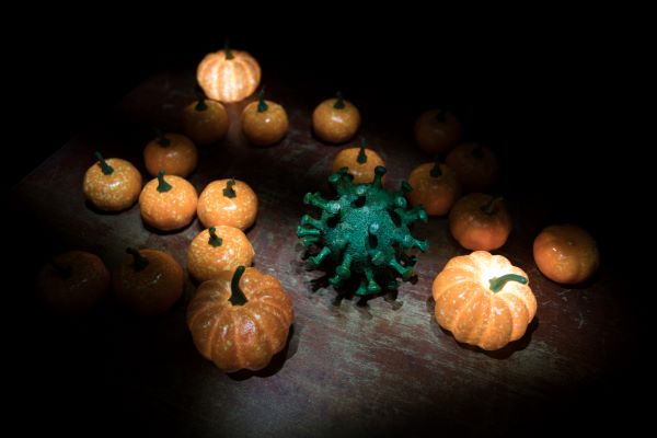 A collection of pumpkins with a green virus in the middle