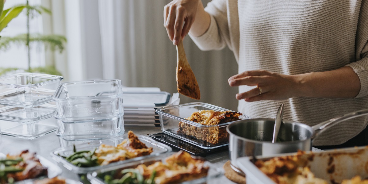 A person prepping meals ahead of time in their kitchen using glass containers.