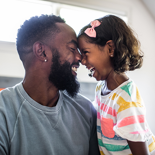 Father and Daughter Laughing In Bedroom