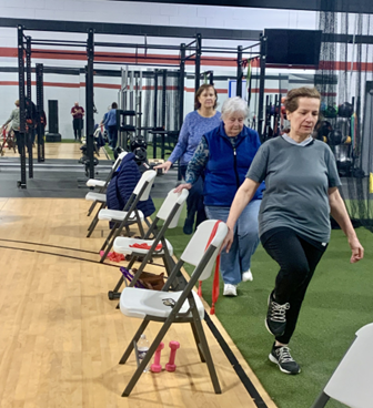 participants exercising with chair for support